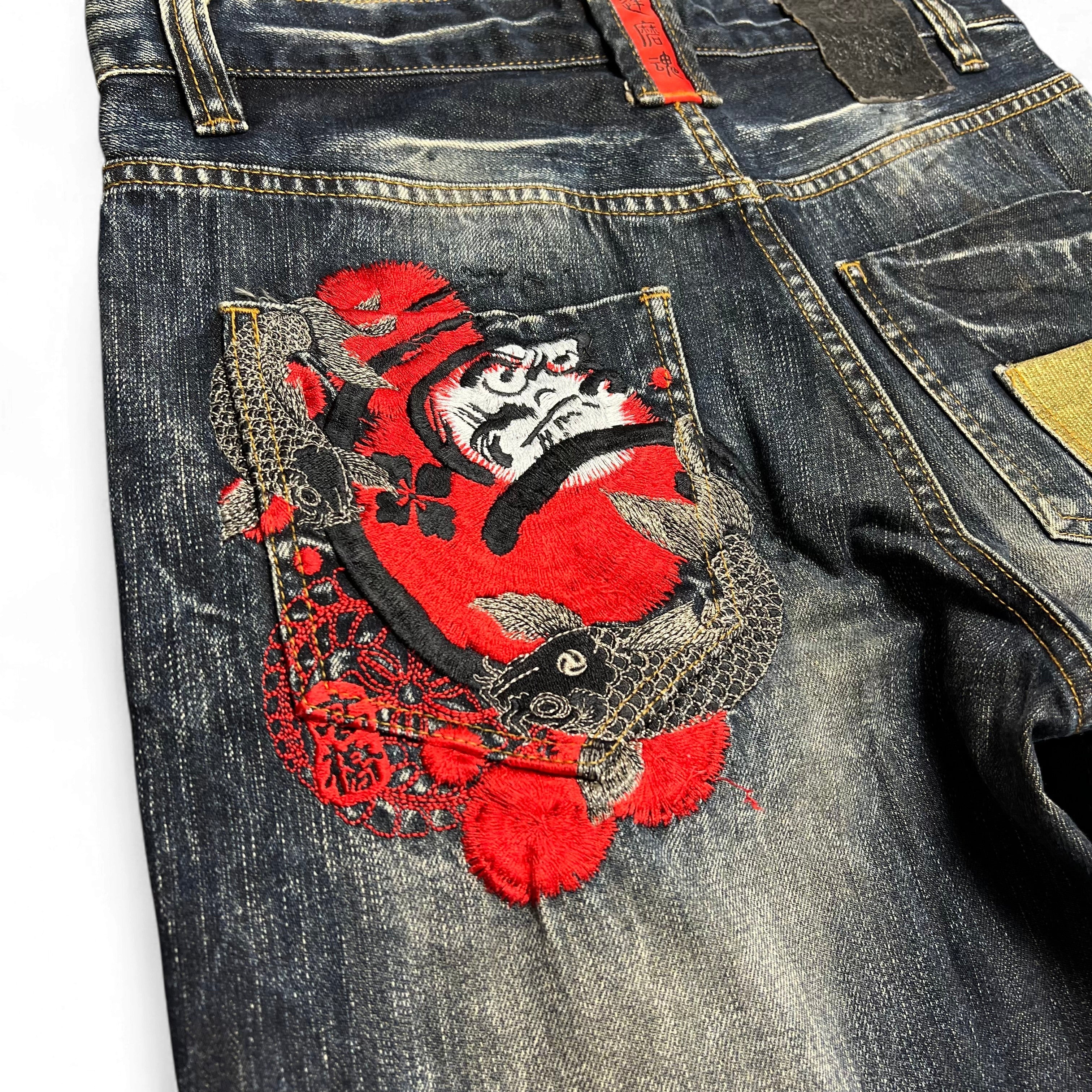 TWC Vintage Jeans mit dunkler Waschung und detaillierter roter Daruma- und Koi-Stickerei auf der Gesäßtasche