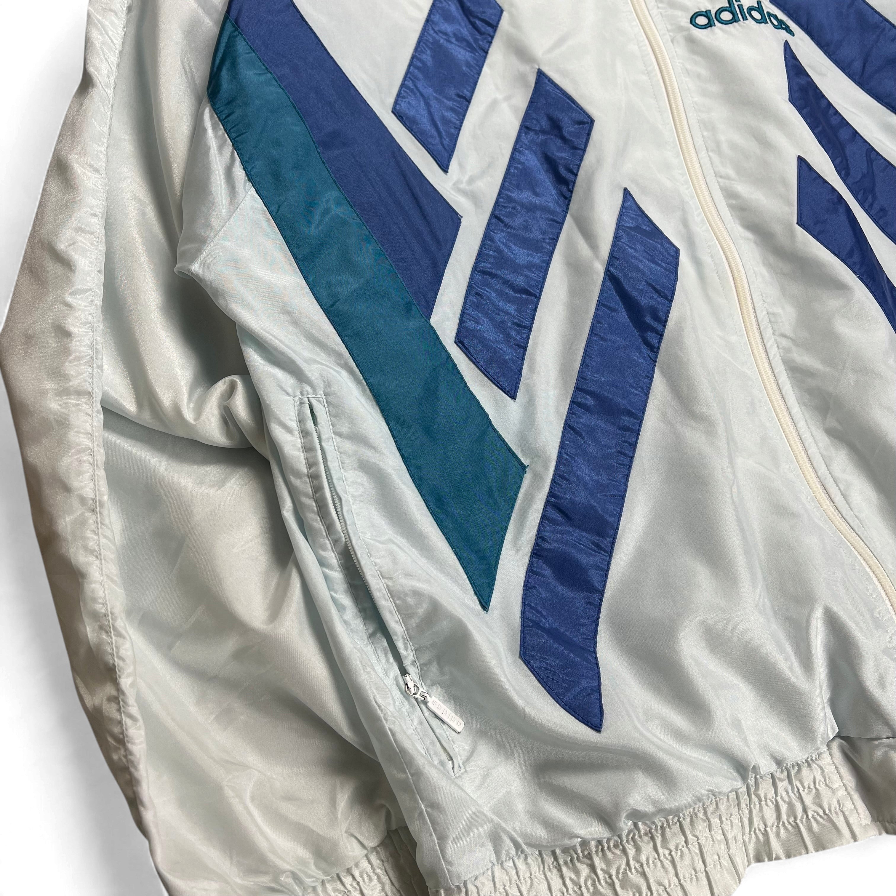 TWC Vintage 90er Jahre Adidas Windbreaker in Hellblau und Weiß mit geometrischen Streifen und Reißverschlusstasche