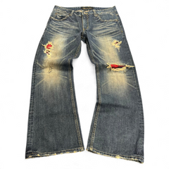 TWC Vintage Bootcut-Jeans in verwaschenem Blau mit Distressed-Details und rot karierten Stoffeinsätzen