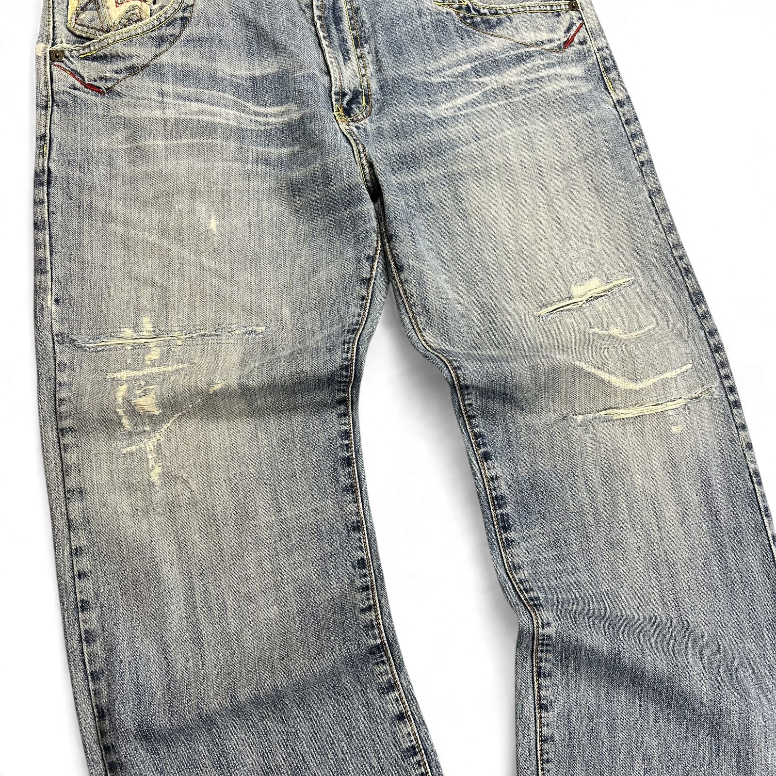 TWC Vintage Jeans aus hellblauem Denim mit japanischer Stickerei und Distressed-Details an den Knien