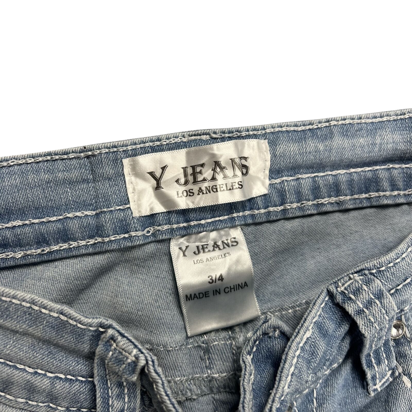 TWC Vintage Y2K Bootcut Jeans in hellblauem Denim mit sichtbarem Markenetikett und Kontrastnähten