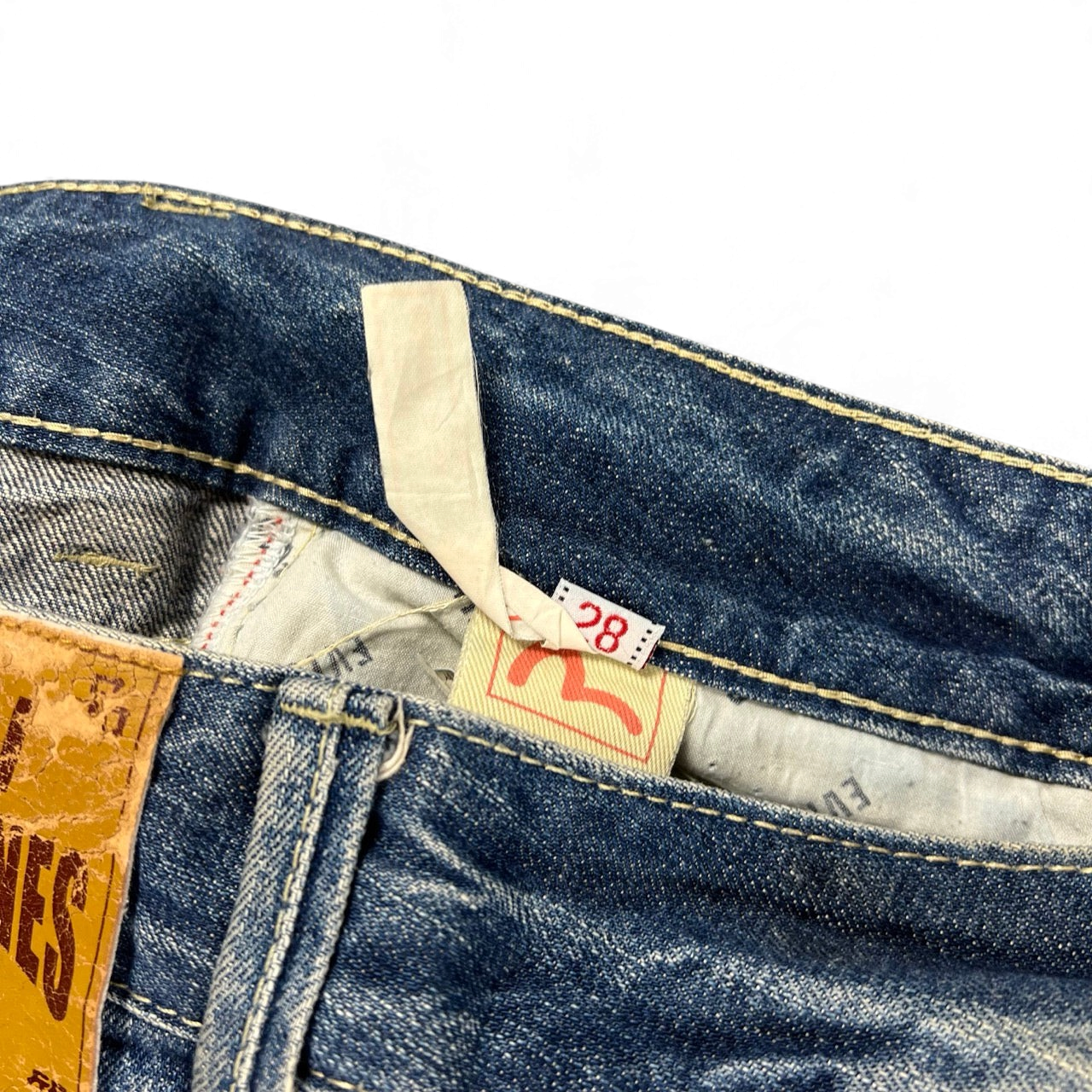 TWC Vintage Evisu straight leg blue denim jeans featuring a size 28 tag and leather brand patch on the waistband.