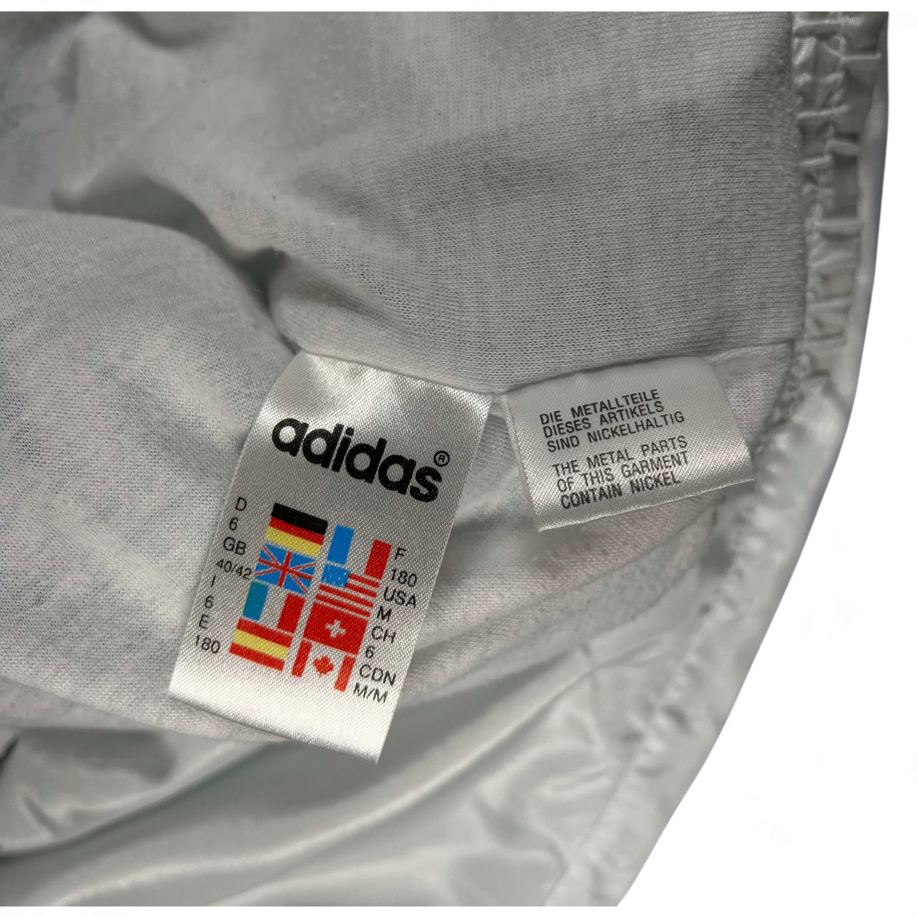 TWC Vintage Adidas 90er Jahre Windbreaker Pflegeetikett mit Größenangaben und Länderflaggen