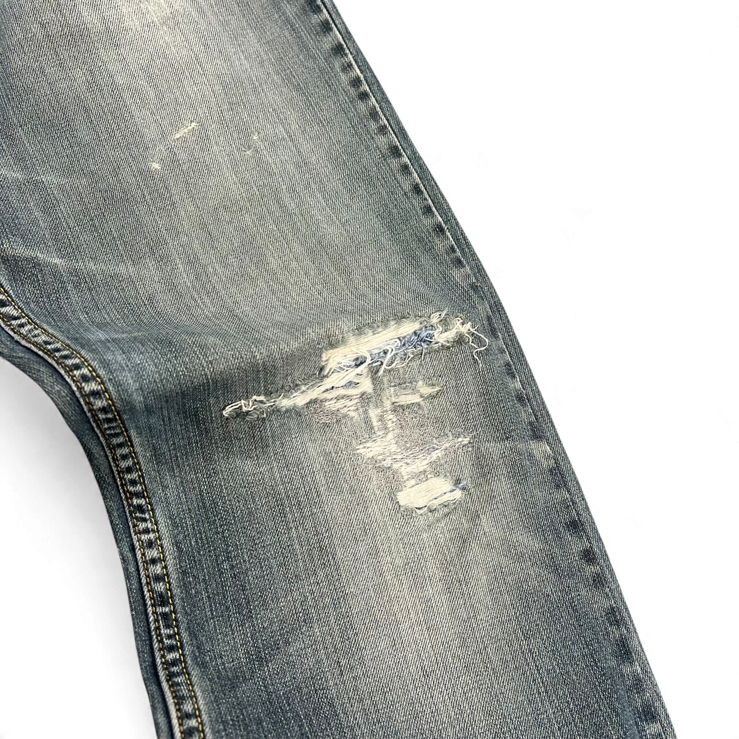 TWC Vintage Levi’s 527 Bootcut Jeans in hellblauem Denim mit markanten Distressed-Details und Abnutzungsspuren am Knie