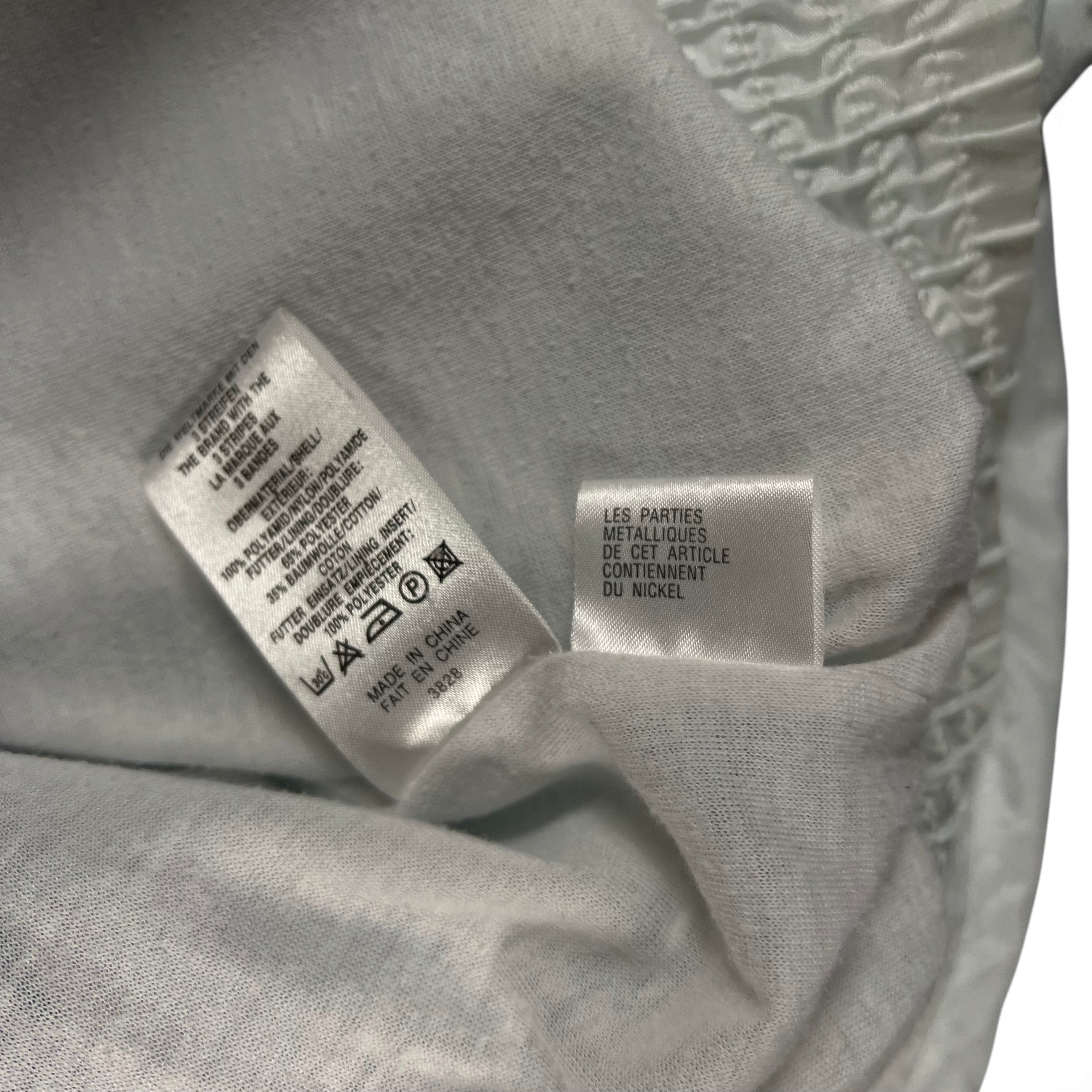 TWC Vintage Adidas Windbreaker Pflegeetikett mit Materialangaben aus Nylon und Baumwolle