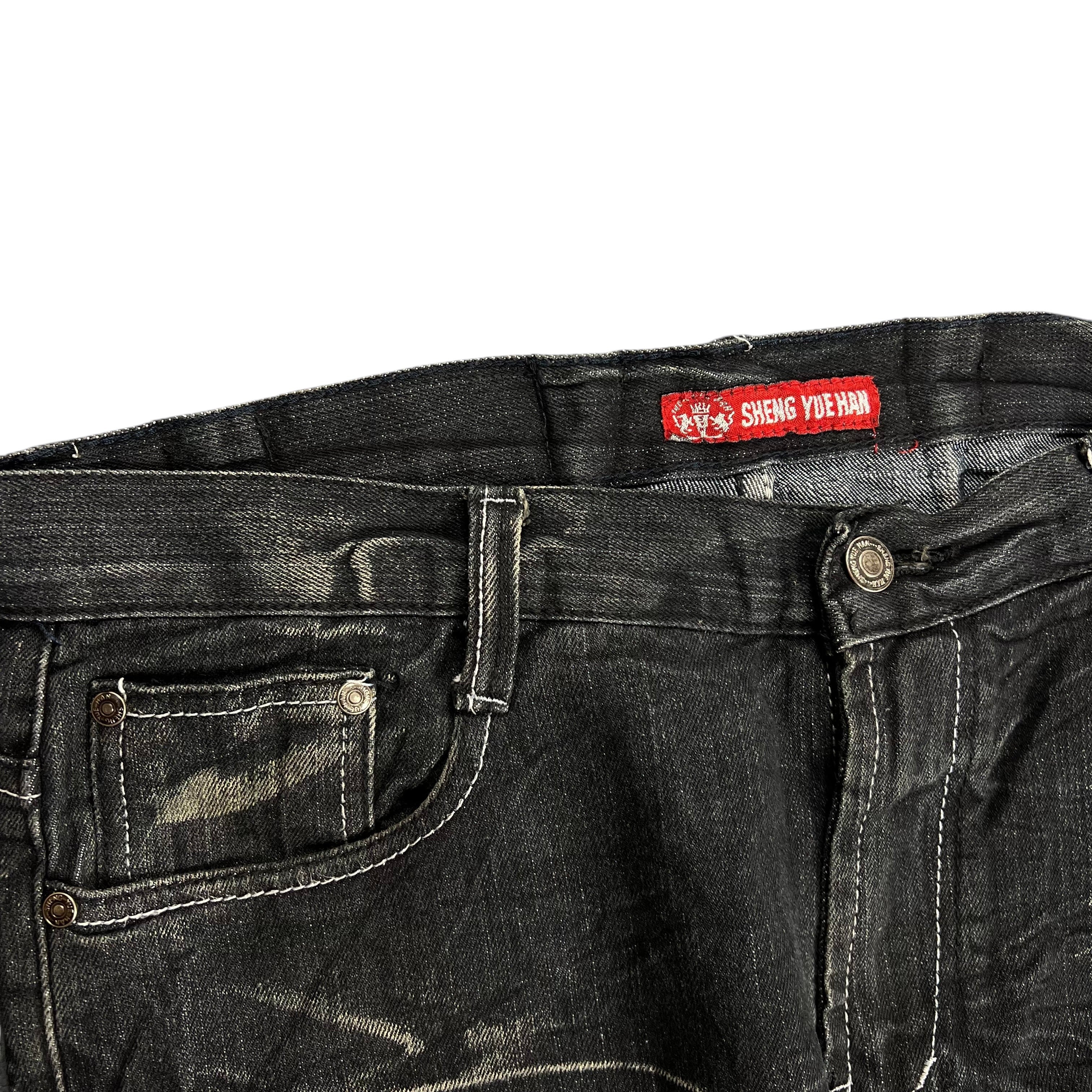 TWC Vintage schwarze Denim-Jeans mit japanischer Stickerei, verwaschener Optik und rotem Markenlabel am Bund.
