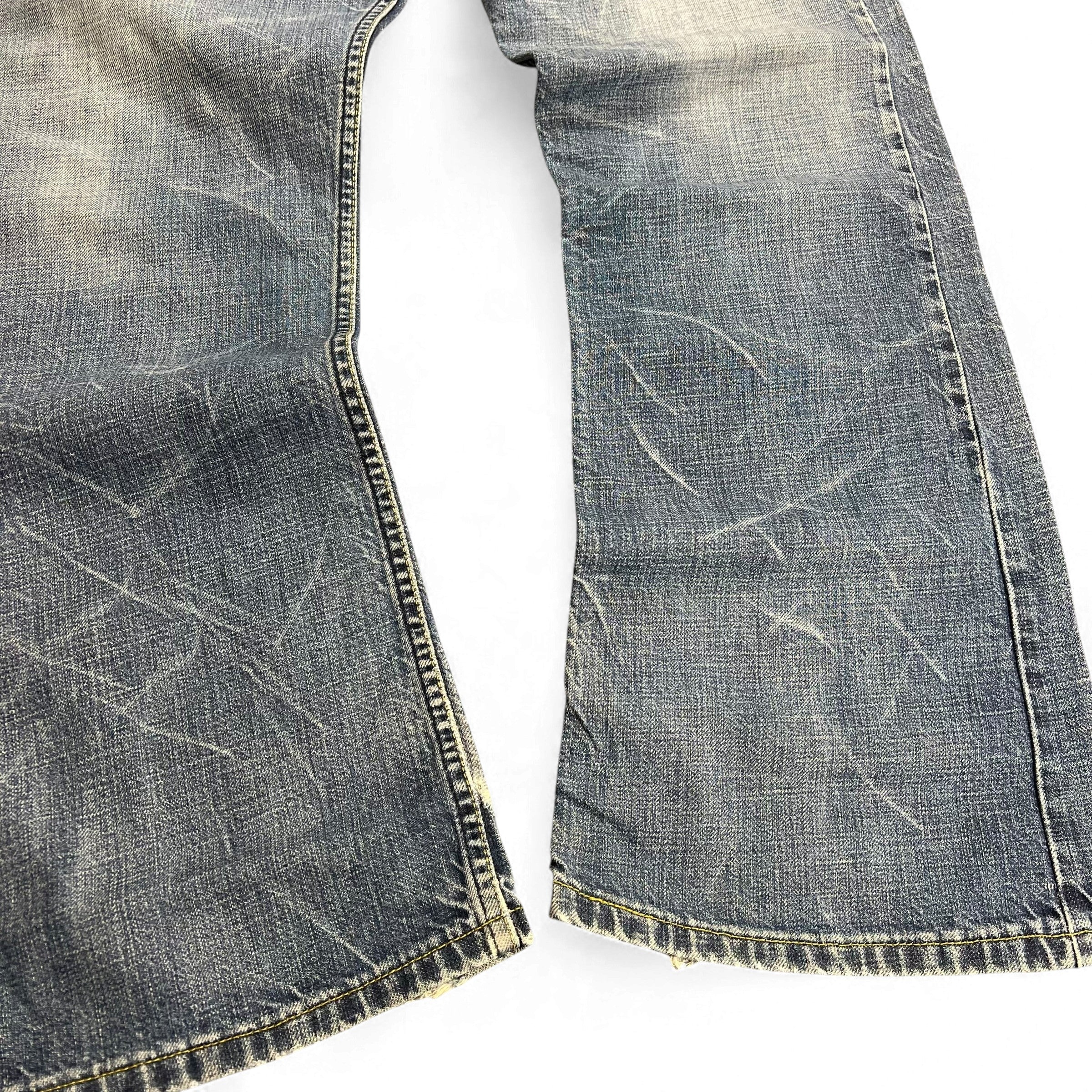TWC Vintage Levi’s 527 Bootcut Jeans in verwaschenem Blau mit markanten Tragespuren und ausgefransten Säumen